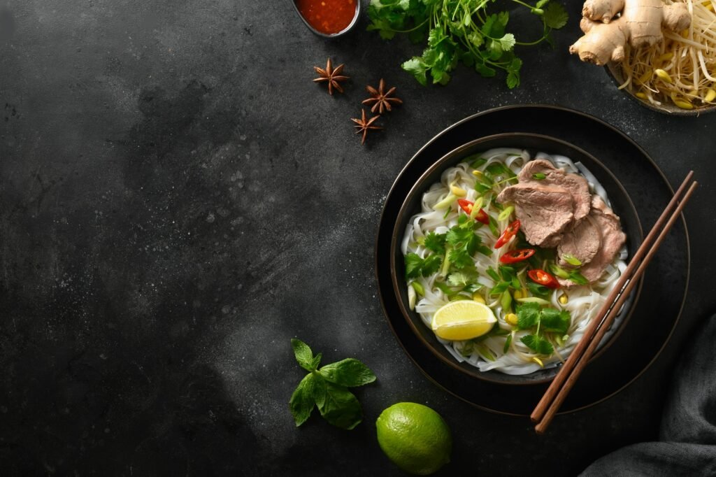 Pho Bo Soup with beef in bowl on black background. Vietnamese cuisine.