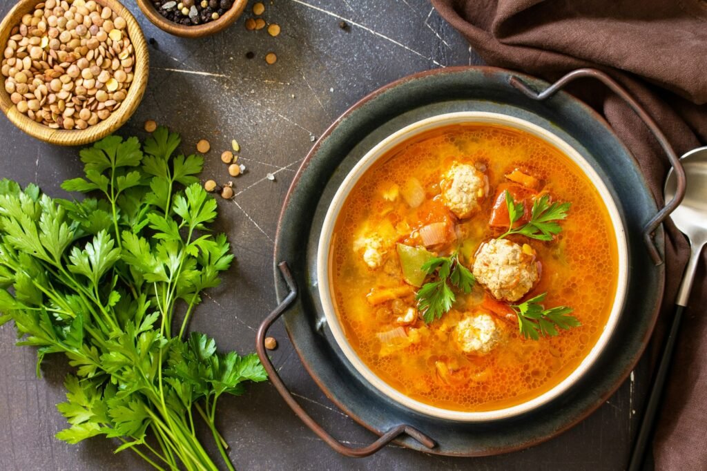 Tomato-lentil soup with meatballs and vegetables.